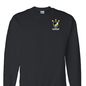 May include: Black sweatshirt with a small embroidered patch on the left chest. The patch features a shield with a lightning bolt and eagle, and the text "U.S. Army Security Agency" and "Military Attaché".