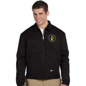 May include: A black work jacket with a zipper closure and a patch on the left chest that reads "1st Cavalry Division - Proudly Served".