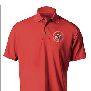 May include: Red polo shirt with a white embroidered logo that reads "101st Field Artillery Command Quick Reliable Accurate". The logo features a blue circle with a white lightning bolt and a red missile.