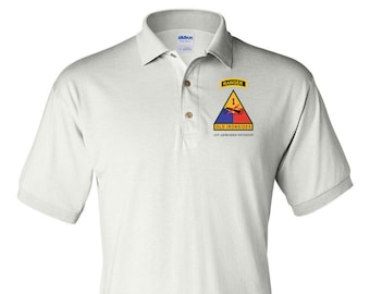May include: White polo shirt with a patch featuring the 1st Armored Division insignia, a yellow triangle with a red tank and blue background, and the text "Old Ironsides 1st Armored Division". The patch also includes a smaller patch with the text "Ranger".