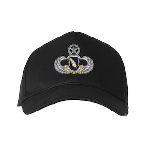 May include: Black baseball cap featuring a detailed emblem with a star, wings, and a shield with the words "STRIKE HOLD". The emblem is in silver, gold, and blue. The cap is a classic six-panel design.
