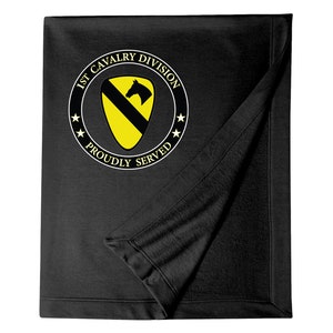 May include: Black fleece blanket with a white circle containing the words "1st Cavalry Division" and a yellow shield with a black horse and a black stripe. The words "Proudly Served" are written below the shield.