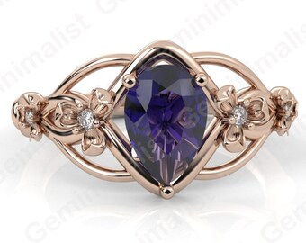 May include: A rose gold ring with a pear-shaped amethyst gemstone set in a delicate floral design.