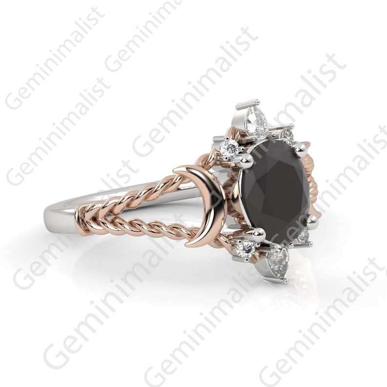 Puede incluir: Un anillo de plata y oro rosa con una piedra preciosa negra rodeada de piedras blancas m&aacute;s peque&ntilde;as. El anillo presenta una banda retorcida y un dise&ntilde;o de luna creciente.