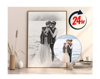 May include: A black and white pencil sketch of a couple standing on a beach, holding each other. The sketch is framed in a gold frame and hanging on a wall. The couple are wearing casual clothing and smiling. The background is a blurry image of the beach.