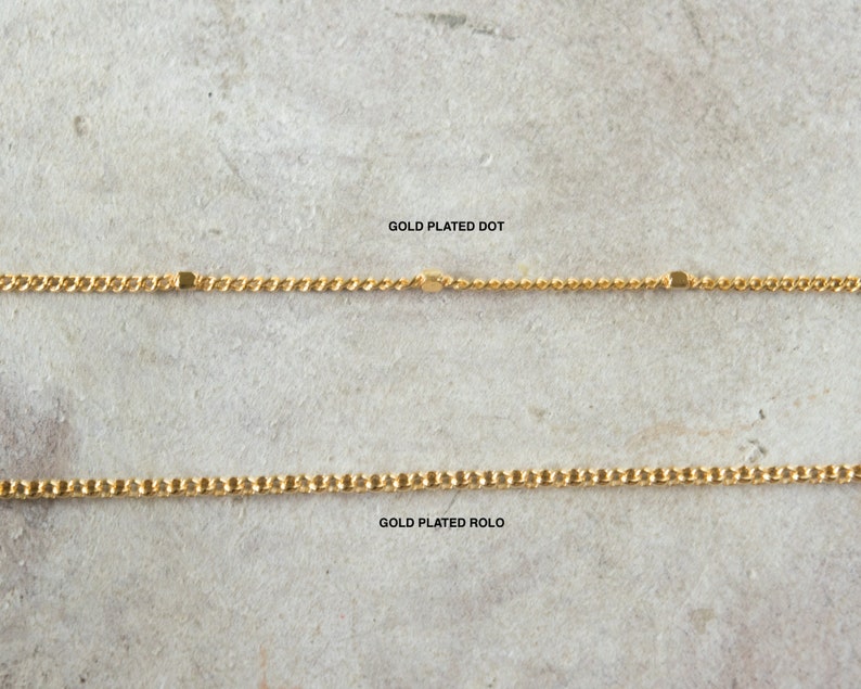 Pode incluir: Duas correntes banhadas a ouro, uma com um padr&atilde;o de pontos e a outra com um padr&atilde;o rolo. O texto "GOLD PLATED DOT" e "GOLD PLATED ROLLO" est&aacute; escrito abaixo de cada corrente.