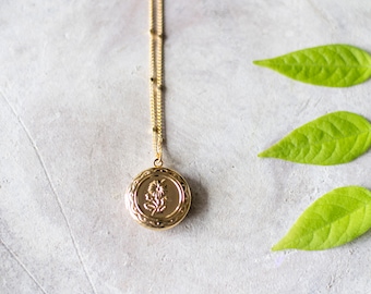 Colar com medalhão gravado em flor dourada: delicado pingente de medalhão