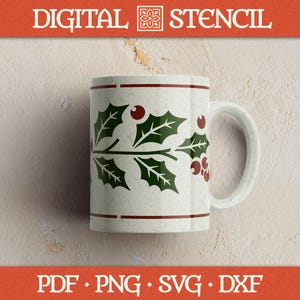 Peut inclure: Une tasse en céramique blanche ornée d'un motif de houx et de baies vertes et rouges. La tasse a une anse et une bande rouge près du haut et du bas. Le texte "DIGITAL STENCIL" est en haut et "PDF • PNG • SVG • DXF" en bas.