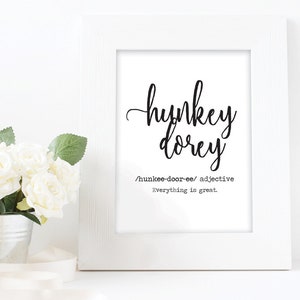 May include: White framed print with black text that reads "hunky dory" and defines the word as an adjective meaning "everything is great."