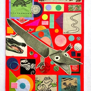 May include: A mixed media collage on a red background featuring a large, gray paper alligator. The artwork includes various geometric shapes, a turtle, a snake, and frogs. The collage uses a variety of colors and textures.