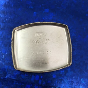 Pu&ograve; includere: Il retro di un orologio placcato oro con il testo "Falco's 14K Gold Filled 995-46" e il numero "428021".