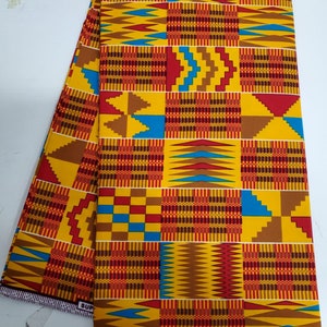 May include: A yellow, red, blue, and brown patterned fabric with a geometric design. The fabric has the text "Holland" printed on the bottom edge.
