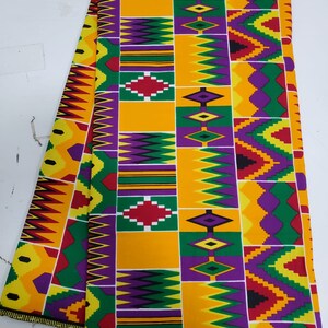 May include: A colorful fabric with a geometric pattern in shades of yellow, green, purple, red, and black. The fabric has a repeating pattern of diamonds and zigzags. The fabric is labeled "SKE 2011".