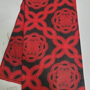 May include: Red and black fabric with a repeating pattern of interlocking circles. The fabric has a label that says "SWA 081".