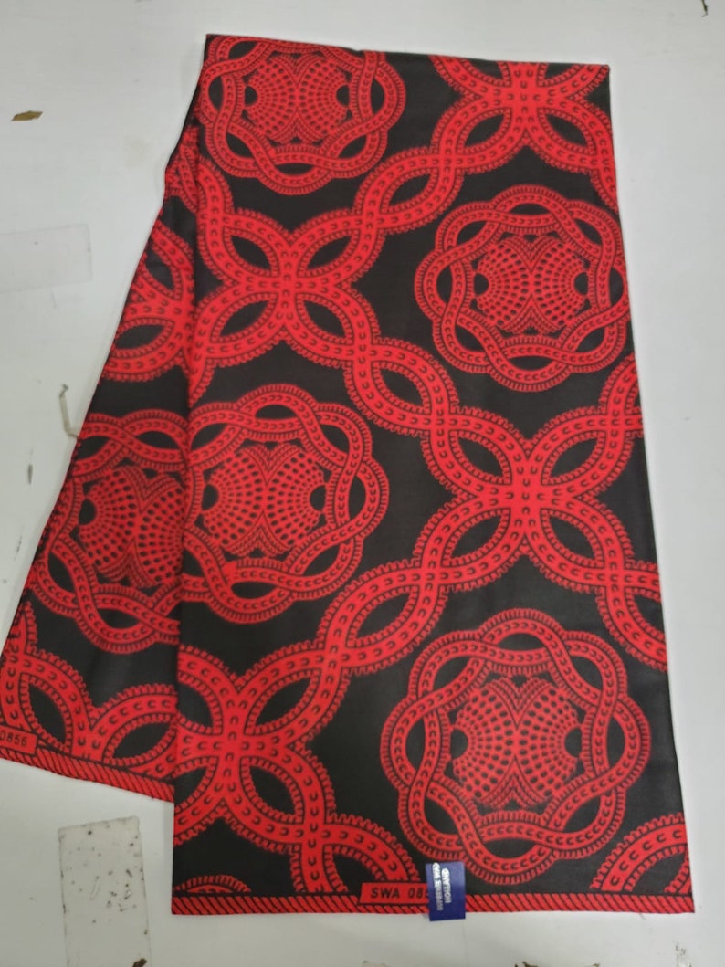 May include: Red and black fabric with a repeating pattern of interlocking circles. The fabric has a label that says "SWA 081".