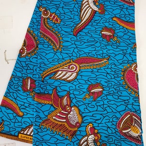 May include: A blue and white fabric with a repeating pattern of stylized birds with red, gold, and white accents. The fabric has the text "SUPREME" and "SWA 0919" printed on it.