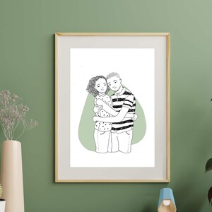 May include: A black and white line drawing of a couple hugging, framed in a light wood frame. The couple is standing on a green background.