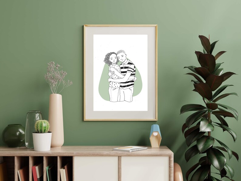 May include: A black and white line drawing of a couple hugging, framed in a light wood frame. The couple is standing on a green background.