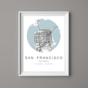 Puede incluir: Un mapa en blanco y negro de San Francisco, California, con un círculo azul claro a su alrededor. El texto "SAN FRANCISCO" y "CALIFORNIA" está debajo del mapa, junto con las coordenadas "37.7576793 / -122.5076404".