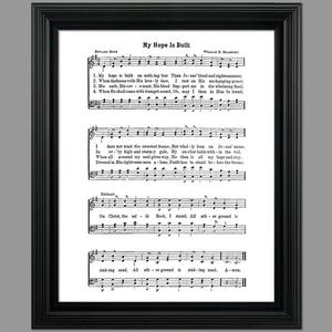 May include: A vintage sheet music print of the hymn "My Hope Is Built" by Edward Mote and William B. Bradbury. The sheet music features the lyrics and musical notation for the hymn.