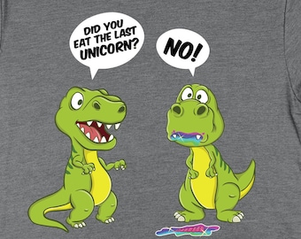 May include: Grey t-shirt featuring a cartoon dinosaur design. The text on the shirt reads "Did you eat the last unicorn? No!"