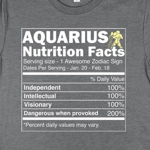 May include: Gray t-shirt with a white graphic of a nutrition facts label for Aquarius. The label lists traits like "Independent", "Intellectual", "Visionary", and "Dangerous when provoked" with a percentage value of 100% or 200%.