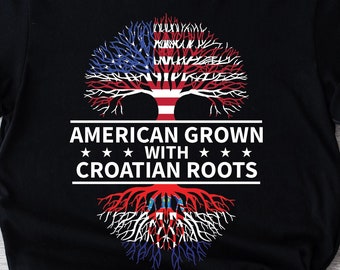 Può includere: Maglietta nera con un design ad albero con la bandiera americana e la bandiera croata. Il testo "American Grown with Croatian Roots" è stampato sulla maglietta.