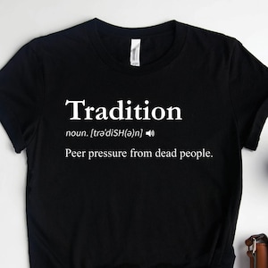 May include: Black t-shirt with white text that reads "Tradition" and a definition of the word as "peer pressure from dead people."
