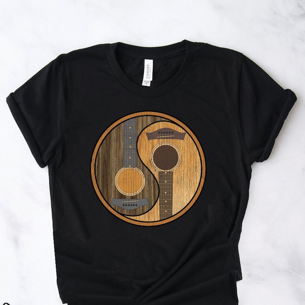 Könnte beinhalten: Schwarzes T-Shirt mit einem Yin-Yang-Symbol-Design mit zwei Akustikgitarren. Die Gitarren sind in einem Holzmaserungsmuster dargestellt.