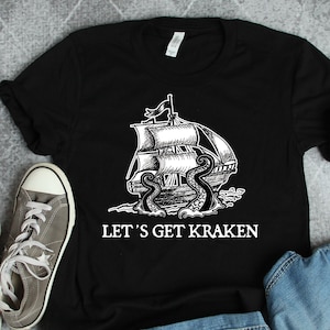 May include: Black t-shirt with a white graphic of a ship being attacked by a kraken. The text "Let's Get Kraken" is printed below the graphic.