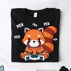 May include: Black t-shirt with a red panda holding a video game controller. The panda is surrounded by the word "pew" in white text.