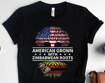 May include: Black t-shirt with a tree design. The tree's branches are formed by the American flag and the roots are formed by the Zimbabwean flag. The text reads "American Grown with Zimbabwean Roots".
