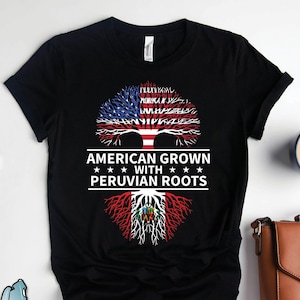 May include: Black t-shirt with a tree design featuring the American and Peruvian flags. The text "American Grown with Peruvian Roots" is printed on the shirt.