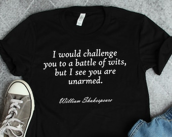 May include: Black t-shirt with a white quote that reads "I would challenge you to a battle of wits, but I see you are unarmed."  The quote is attributed to William Shakespeare.