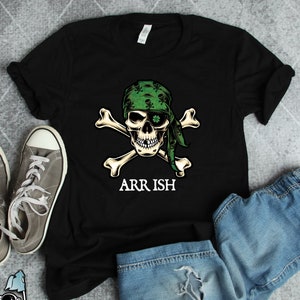 May include: Black t-shirt with a green skull and crossbones design. The skull is wearing a green bandana with shamrocks. The text "ARR ISH" is below the skull.