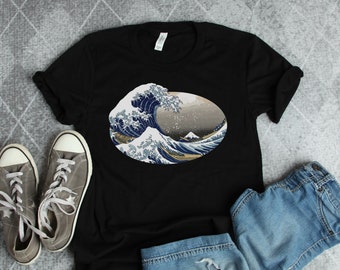 May include: Black t-shirt with a graphic print of a blue and white wave, reminiscent of the Great Wave off Kanagawa by Hokusai.