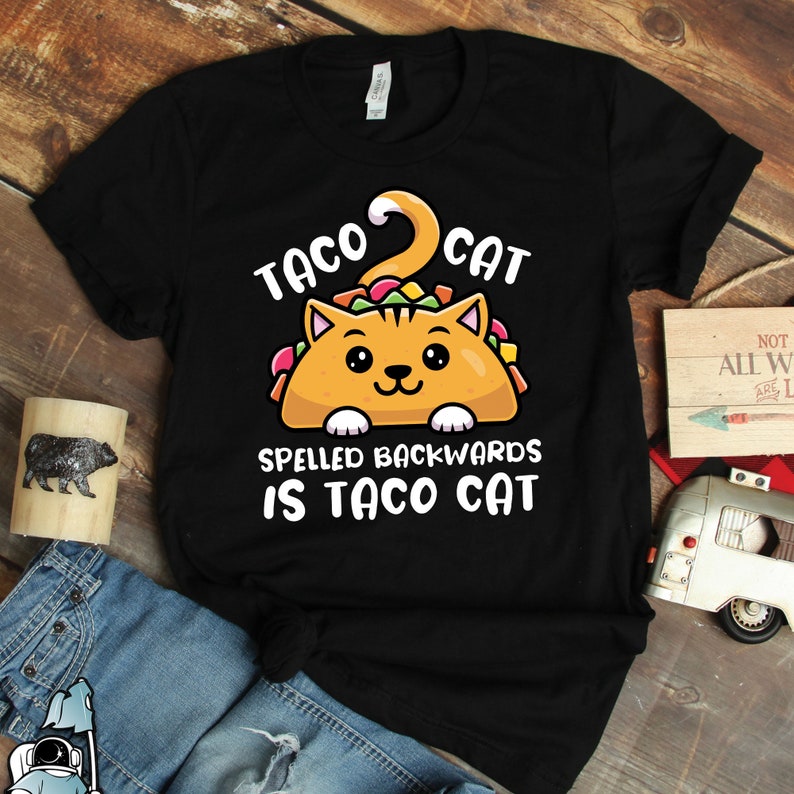 May include: Black t-shirt with a cartoon cat inside a taco. The text reads "Taco Cat Spelled Backwards Is Taco Cat".