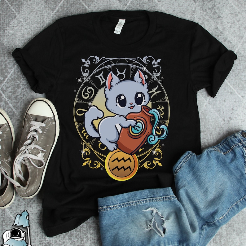 May include: Black t-shirt with a cartoon illustration of a gray cat holding a blue and white water pitcher. The cat is surrounded by a gold zodiac symbol with the text "Aquarius".