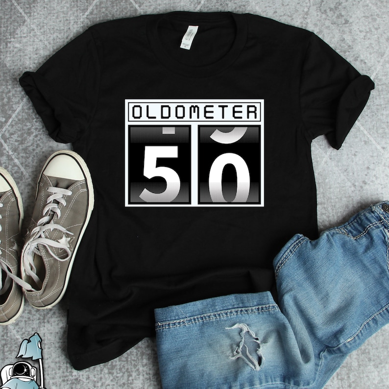 Pu&ograve; includere: Maglietta nera con una grafica bianca di un contachilometri digitale che mostra "50". La grafica &egrave; in un rettangolo bianco con la parola "OLDOMETER" sopra i numeri.