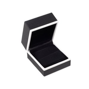 May include: An empty black ring box with a white trim. The box is open and the lid is propped up.