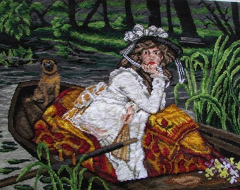 May include: A woman in a white dress and a hat sits in a boat with a dog. The boat is on a river with green reeds on the banks. The woman is looking off to the side and has her hand on her chin. The dog is sitting in the boat and looking at the camera.
