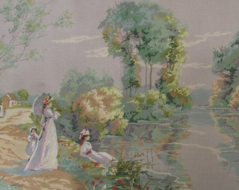 May include: A vintage needlepoint canvas depicting a pastoral scene with three women in long dresses standing by a lake. The women are holding parasols and are surrounded by trees and greenery. The lake is calm and reflects the sky and trees. The canvas is in a light gray color and has a textured surface.