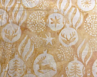 May include: Close-up of a fabric with a repeating pattern of white Christmas ornaments, reindeer, and stars on a tan background. The design includes various shapes of ornaments, trees, and reindeer, creating a festive holiday theme.