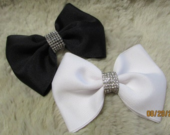 May include: Two large hair bows, one black and one white, with a rhinestone center.