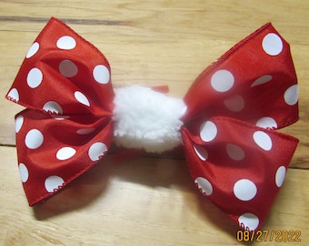 May include: A red and white polka dot bow with a white fluffy center.