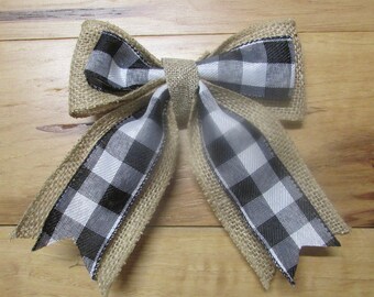 May include: A large bow made with burlap and black and white checkered ribbon. The bow is tied with a loop in the center.