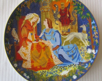 May include: A decorative plate with a colorful illustration of a king and queen in a medieval setting. The plate features a blue background with gold accents and intricate details. The scene depicts a king and queen in a castle, surrounded by flowers and foliage. The plate is a beautiful example of medieval art and would make a great addition to any collection.