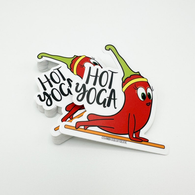 May include: A stack of white stickers with a red chili pepper doing a yoga pose. The text "HOT YOGA" is written in black on the sticker.
