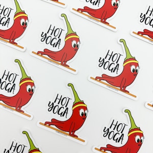 May include: A set of nine red chili pepper stickers with green stems and yellow bands. Each sticker features the text "HOT YOGA" in black cursive lettering.
