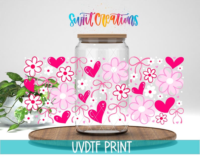 a glass jar with a lid, decorated with pink hearts, flowers, and bows, placed on a wooden surface.